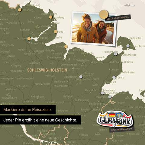 Detail einer magnetischen Deutschland-Karte als Magnettafel in Olive Green zeigt Schleswig-Holstein mit einem angepinnten Urlaubsfoto sowie Reise- und Urlaubsmagnete