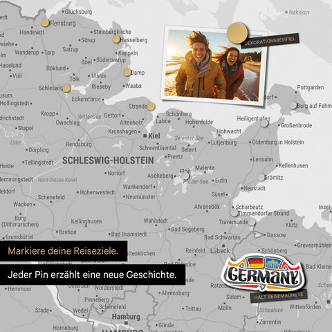 Detail einer magnetischen Deutschland-Karte als Magnettafel in Coolgray (Hellgrau) zeigt Schleswig-Holstein mit einem angepinnten Urlaubsfoto sowie Reise- und Urlaubsmagnete