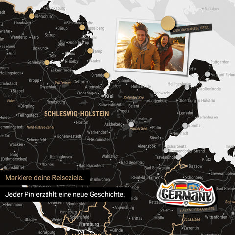 Detail einer magnetischen Deutschland-Karte als Magnettafel in Light Black zeigt Schleswig-Holstein mit einem angepinnten Urlaubsfoto sowie Reise- und Urlaubsmagnete