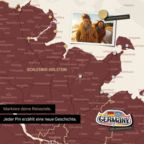 Detail einer magnetischen Deutschland-Karte als Magnettafel in Bordeaux Rot zeigt Schleswig-Holstein mit einem angepinnten Urlaubsfoto sowie Reise- und Urlaubsmagnete