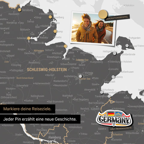Detail einer magnetischen Deutschland-Karte als Magnettafel in Light Gray zeigt Schleswig-Holstein mit einem angepinnten Urlaubsfoto sowie Reise- und Urlaubsmagnete