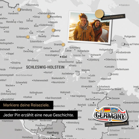 Detail einer magnetischen Deutschland-Karte als Magnettafel in Multicolor Gray zeigt Schleswig-Holstein mit einem angepinnten Urlaubsfoto sowie Reise- und Urlaubsmagnete