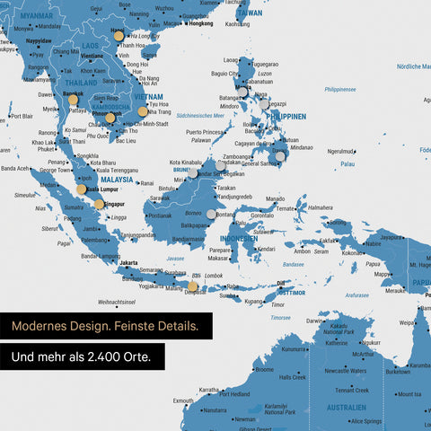 Ausschnitt einer magnetischen Weltkarte in Blau zeigt Karte von Asien, auf der Magnete Reiseziele markieren